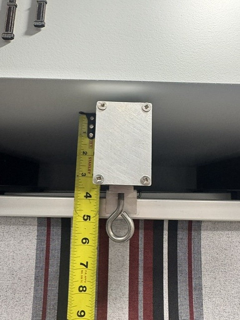 Close-up of triple-track canopy mounting bracket with tape measure