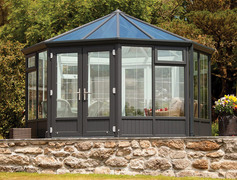 A spacious sunroom with insulated and double-glazed panels, set on a stone foundation, designed for outdoor relaxation.