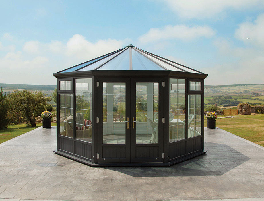 Hexagonal glasshouse on a patio with scenic view